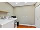 Practical laundry room with modern washer and dryer, upper storage shelf, and clean white walls and fixtures at 8330 Claridge Rd, Indianapolis, IN 46260
