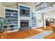 Stylish living room with custom built-in shelves, fireplace, a TV, and views of the adjacent kitchen at 8330 Claridge Rd, Indianapolis, IN 46260