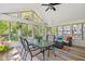 Well-lit sunroom with a glass top table and couches with colorful pillows at 8330 Claridge Rd, Indianapolis, IN 46260