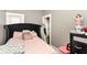Cozy bedroom with a black upholstered bed frame, soft pink bedding, and ample natural light at 853 S Belleview Pl, Indianapolis, IN 46221