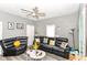 Inviting living room featuring a black leather sofa, modern ceiling fan, and neutral gray walls at 853 S Belleview Pl, Indianapolis, IN 46221