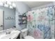 Light filled bathroom with floral shower curtain and white toilet at 8581 N Goat Hollow Rd, Mooresville, IN 46158