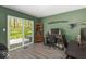 Bright office with green walls, laminate flooring, and a sliding door to the outside at 8581 N Goat Hollow Rd, Mooresville, IN 46158