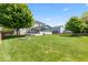 Spacious backyard with well-maintained lawn, fire pit, and a view of the screened-in porch at 8635 Nolan Dr, Fishers, IN 46038
