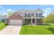 Charming two-story home with a brick facade, covered porch, and well-manicured lawn at 8635 Nolan Dr, Fishers, IN 46038