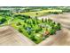 Aerial view of a house and property that includes a pond, yard, trees, and an additional red-roofed outbuilding at 893 W 500 S, Anderson, IN 46013