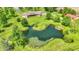 Aerial image of a beautiful estate with a large pond, grassy yard, and mature trees surrounding the brick home at 893 W 500 S, Anderson, IN 46013