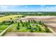 Wide aerial view of a home on a large lot with a pond, mature trees, and separate red barn in the countryside at 893 W 500 S, Anderson, IN 46013