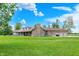 Expansive backyard featuring a brick home with a covered patio and attached three-car garage at 893 W 500 S, Anderson, IN 46013