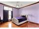 Bright bedroom features hardwood floors, lavender colored walls, and a queen sized bed at 893 W 500 S, Anderson, IN 46013