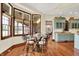 Bright breakfast nook features a round glass table, seating for four, and natural light from large windows at 893 W 500 S, Anderson, IN 46013