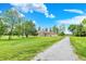 Spacious front yard features lush green grass, mature trees, and a long gravel driveway at 893 W 500 S, Anderson, IN 46013