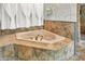 Elegant bathroom with a large corner soaking tub, tiled surround, and gold fixtures at 893 W 500 S, Anderson, IN 46013