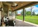Covered patio with brick accents, ceiling fan, and views of the lush green lawn and landscaping at 893 W 500 S, Anderson, IN 46013