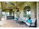 Covered patio with outdoor seating, ceiling fans, brick accents, and access to the hot tub at 893 W 500 S, Anderson, IN 46013