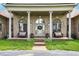 Covered front porch featuring white columns, seating, and decorative plants and wreath at 893 W 500 S, Anderson, IN 46013