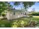 Exterior rear of home with a small deck, a large yard, and plenty of trees at 953 W Clinton St, Danville, IN 46122