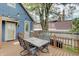 Back deck with outdoor seating, attached to a blue house, and adjacent to a fenced yard at 1009 Broadway St, Indianapolis, IN 46202