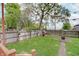 Fenced backyard with lush lawn, playhouse, paver patio, and view of trees at 1009 Broadway St, Indianapolis, IN 46202
