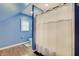 Cozy bathroom showcasing a toilet, window, blue walls, and a shower with a white curtain at 1009 Broadway St, Indianapolis, IN 46202