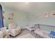 Inviting Bedroom filled with natural light, a cozy armchair, and playful decor for a comforting space at 1009 Broadway St, Indianapolis, IN 46202