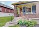Inviting front porch with brick pillars, flower accents and a cozy porch swing at 1009 Broadway St, Indianapolis, IN 46202