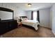 Bedroom featuring carpeting, a window with curtains, a bed with a dark wood frame, and dark furniture at 10836 Zimmerman Ln, Indianapolis, IN 46231