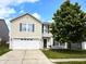 Charming two-story home with a well-manicured lawn, beautiful tree, and attached two-car garage at 10836 Zimmerman Ln, Indianapolis, IN 46231