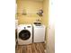 Laundry room equipped with a front-load washer, a top-load dryer, and overhead storage shelves at 10836 Zimmerman Ln, Indianapolis, IN 46231
