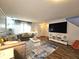 Bright living room featuring a large TV, stylish rug, hardwood floors, and contemporary furniture at 10836 Zimmerman Ln, Indianapolis, IN 46231