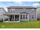Expansive backyard view showcasing the home's exterior, covered patio, and lush green lawn at 10993 Liberation Trce, Noblesville, IN 46060