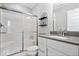 Modern bathroom with a walk-in shower, glass door, gray countertop, and sleek white vanity at 10993 Liberation Trce, Noblesville, IN 46060
