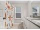 Bright bathroom featuring double sinks, white cabinetry, a toilet, and a themed shower curtain at 10993 Liberation Trce, Noblesville, IN 46060