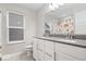 Bright bathroom featuring double sinks, white cabinetry, a toilet, and a view out the window at 10993 Liberation Trce, Noblesville, IN 46060