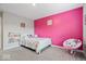 Cozy bedroom with a bright pink wall, stuffed chair and a comfortable single bed at 10993 Liberation Trce, Noblesville, IN 46060