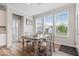 Bright dining room with large windows, gray wood floors and a modern dining table at 10993 Liberation Trce, Noblesville, IN 46060