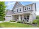 Beautiful two-story home with a brick facade, covered porch, and green lawn at 10993 Liberation Trce, Noblesville, IN 46060