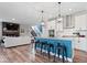 Kitchen island with barstool seating, modern lighting, stainless hood, and open layout to Gathering room at 10993 Liberation Trce, Noblesville, IN 46060