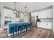 Kitchen island with seating, stainless appliances, range hood, and adjacent pantry at 10993 Liberation Trce, Noblesville, IN 46060