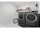 Convenient laundry room with modern, front-load washer and dryer units and storage shelving above at 10993 Liberation Trce, Noblesville, IN 46060