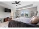Bright main bedroom with a ceiling fan, TV, tray ceiling, bike and a view of the neighborhood at 10993 Liberation Trce, Noblesville, IN 46060