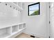 Well-organized mudroom with built-in shelves, hooks, and a bright window at 1100 English Ave, Indianapolis, IN 46203