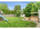 Expansive backyard featuring a playset, a wooden deck, and lush green grass at 113 Spring Creek Ct, Noblesville, IN 46062