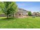 A spacious backyard features a wooden deck, a pergola, mature trees, and a play set, perfect for outdoor activities at 113 Spring Creek Ct, Noblesville, IN 46062