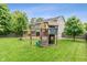 Spacious backyard with a wooden deck, playset, and well-maintained lawn at 113 Spring Creek Ct, Noblesville, IN 46062