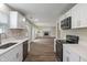 Charming kitchen showcasing stainless steel appliances and white cabinets that flow into an open-concept living space at 113 Spring Creek Ct, Noblesville, IN 46062