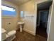 Bathroom with toilet and pedestal sink and tile floor, window with natural light at 1137 W 34Th St, Indianapolis, IN 46208