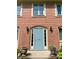 Close-up of a brick home's arched doorway with a light blue door and plants at 1150 Canterbury Ct # Apt D, Indianapolis, IN 46260