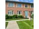 Charming brick townhouse with a blue front door and well-maintained landscaping at 1150 Canterbury Ct # Apt D, Indianapolis, IN 46260