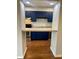 View of the kitchen with bright blue cabinets from the breakfast bar at 1150 Canterbury Ct # Apt D, Indianapolis, IN 46260